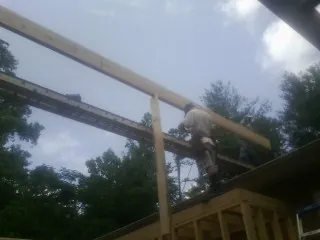 Carpenter setting a ridge beam over a new addition frame — Ice Dam Removal by Roofing Brothers in Pinon Hills