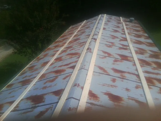 Rusted metal roof panels with new wood purlins before replacement — Storm Damage Roof Repair in Pinon Hills by Roofing Brothers