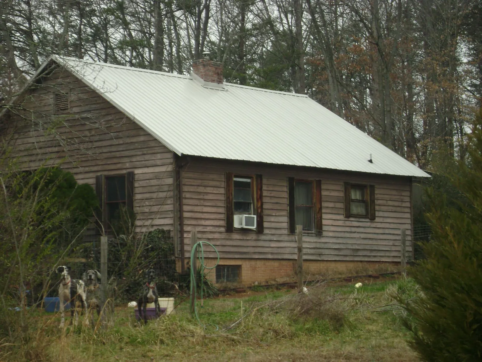 White metal roof on an old wood sided farmhouse, from a Metal Roof Installation job in Pinon Hills